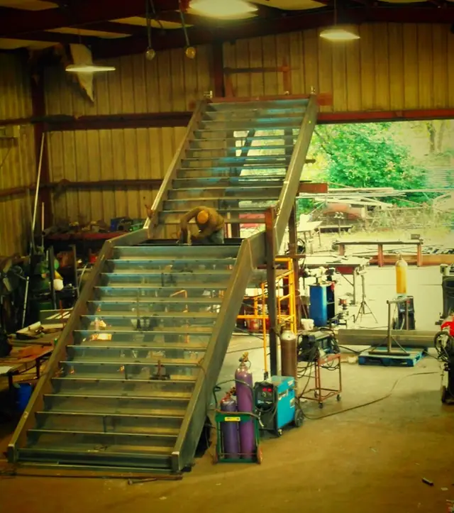 A stair under assembly on the Pool Custom Ironworks shop floor